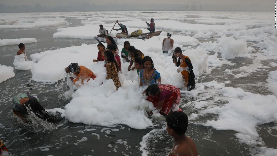 Hindúes se bañan en río sagrado cubierto de espuma tóxica